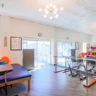 A modern and spacious physical therapy rehabilitation center equipped with exercise tools and a welcoming atmosphere.
