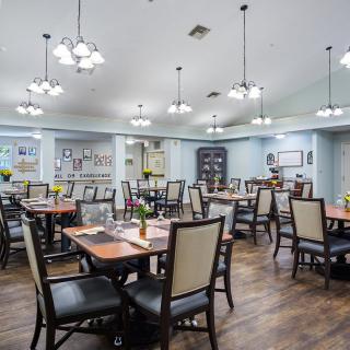 A well-lit dining area with neatly arranged tables and chairs.
