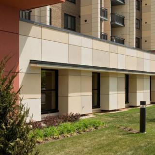 A modern building exterior with grassy landscaping.