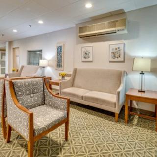 A cozy lobby seating area with comfortable furniture and decorative artwork.