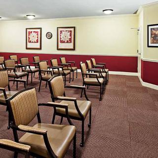 An empty conference room with rows of chairs arranged for a meeting.