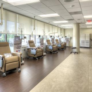 An empty medical treatment area with several reclining chairs and equipment.