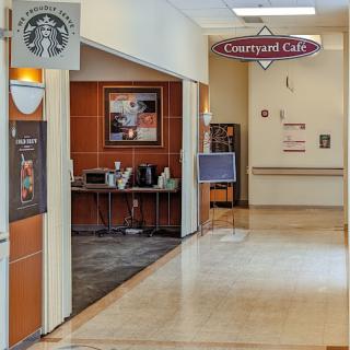 A view of a Starbucks coffee shop next to an airport lounge, featuring a clean and modern interior design.