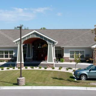 A single-story house with a front lawn and a parked car.
