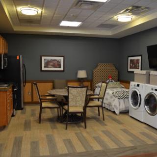 A cozy interior space featuring a kitchen and dining area with laundry facilities.