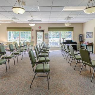 A spacious waiting room featuring rows of green chairs, ideal for gatherings or meetings.