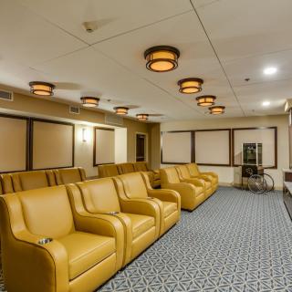 A stylish home theater room with plush seating and ambient lighting.