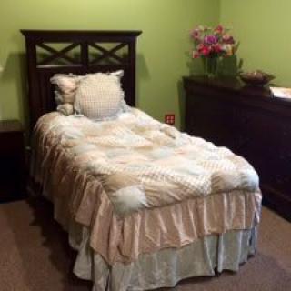 A cozy bedroom with a single bed and green walls.