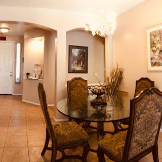 A beautifully arranged dining area featuring an elegant table and chairs, complemented by tasteful artwork and lighting.