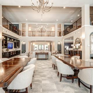 A luxurious and elegant dining room with spacious seating and a grand chandelier.