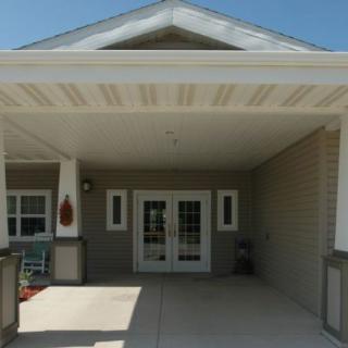 Entrance of a building with a covered porch and double doors.