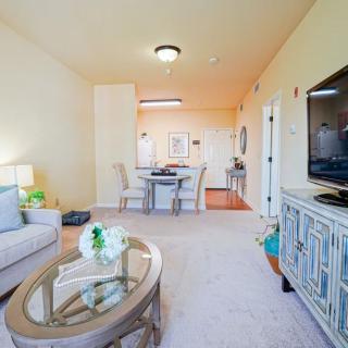 A bright and spacious living room with a dining area, featuring modern furniture and decor.