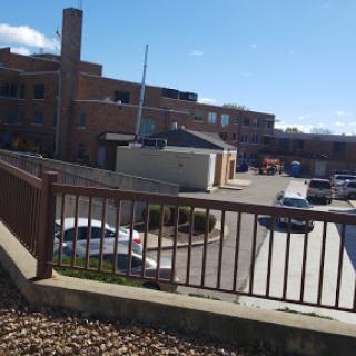 A view of a parking area beside a building under a partly cloudy sky.