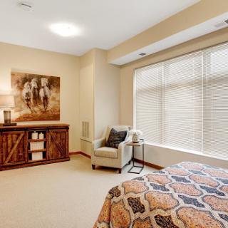A cozy and well-decorated bedroom featuring a serene color palette and tasteful artwork.