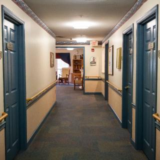 A quiet hotel hallway with doors on either side and soft lighting.