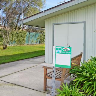 A house with a well-maintained backyard and a for sale sign in the yard.