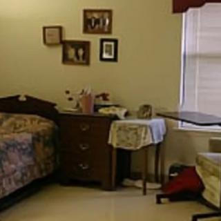 A cozy room with a hospital bed, dresser, and various decorations on the wall.