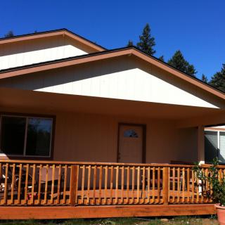 A house with a wooden deck under a clear blue sky.