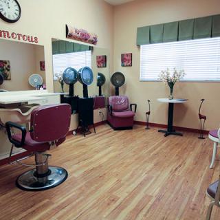 A cozy hair salon with chairs, mirrors, and hairdryers set up for clients.