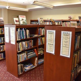 A cozy library with wooden bookshelves filled with various books.