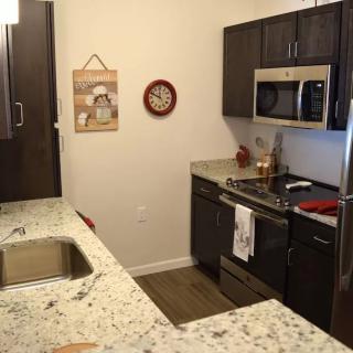 A modern kitchen with granite countertops and stainless steel appliances.