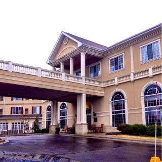 Exterior view of a hotel with classical architectural elements, including columns and arched windows.