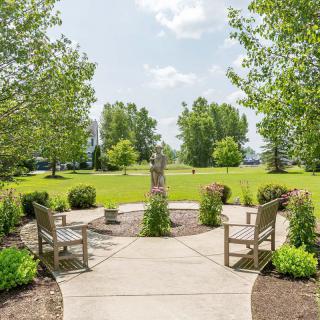 A tranquil park scene featuring benches and lush green surroundings.