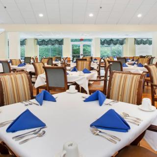 A well-arranged dining area with tables set with blue napkins.