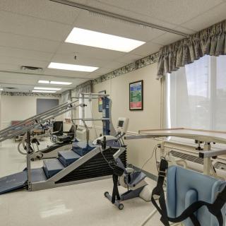 A rehabilitation room equipped with exercise machines and physical therapy tools.