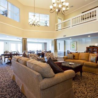 A spacious living room with elegant furnishings and a large chandelier.