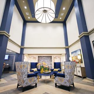 A modern lobby with elegant seating and a large chandelier.