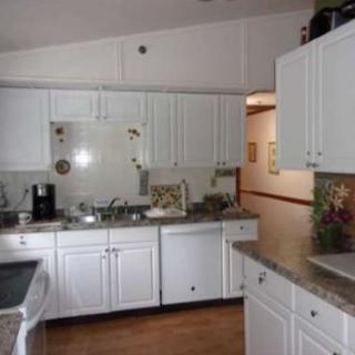 A modern kitchen with white cabinets and countertops.