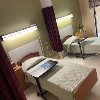 A well-equipped patient room featuring two beds and essential medical amenities.