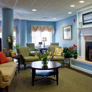A cozy living room with blue walls, featuring a fireplace, comfortable seating, and tasteful decor.