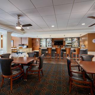 A cozy dining area with a bar, featuring comfortable seating and warm lighting.