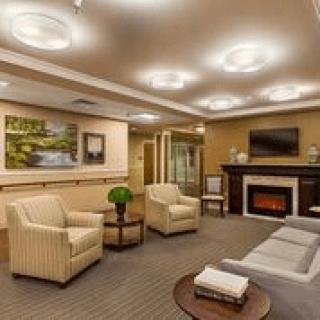 A cozy living room with modern furnishings, featuring a fireplace, comfortable seating, and elegant lighting.