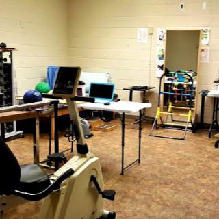 A physical therapy and rehabilitation room equipped with exercise machines and therapy tools.
