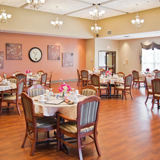 An elegant dining room with tables set for a meal, showcasing a warm and inviting atmosphere.