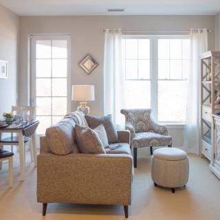 A cozy and well-lit living room with modern decor, featuring a comfortable sofa and armchair.