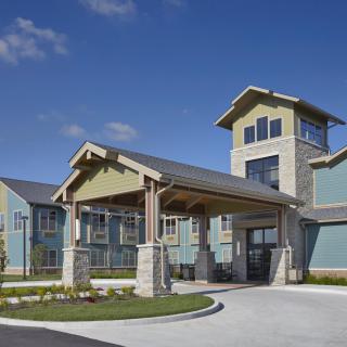 A modern residential building with a prominent entrance and landscaped surroundings.