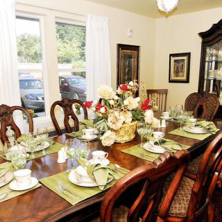 A well-decorated dining room with a large table set for a meal.