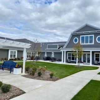 A modern building with a landscaped garden and pathway under a cloudy sky.