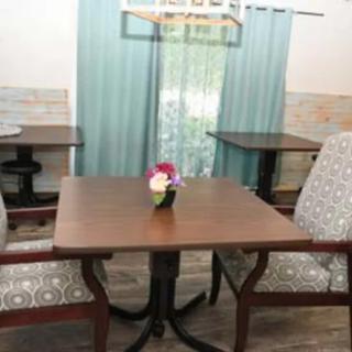 A cozy dining area featuring a wooden table with floral centerpiece and upholstered chairs.