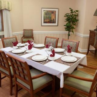 A beautifully arranged dining table ready for a meal, featuring elegant settings and warm decor.