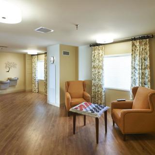 A cozy living room area with two armchairs and a small table set on a wooden floor.