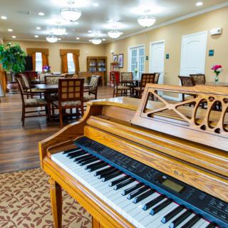 A cozy lounge and dining area featuring a piano and elegant decor.