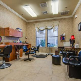 A cozy salon interior featuring multiple chairs and styling stations.