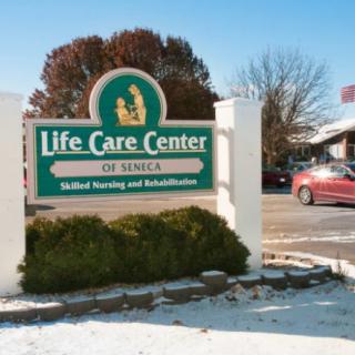 Entrance sign for Life Care Center of Seneca, a medical nursing and rehabilitation facility, with snow on the ground.