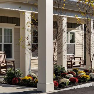 A cozy porch with benches and vibrant flowers.