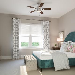 A modern bedroom with a teal bed, patterned curtains, and a ceiling fan.
